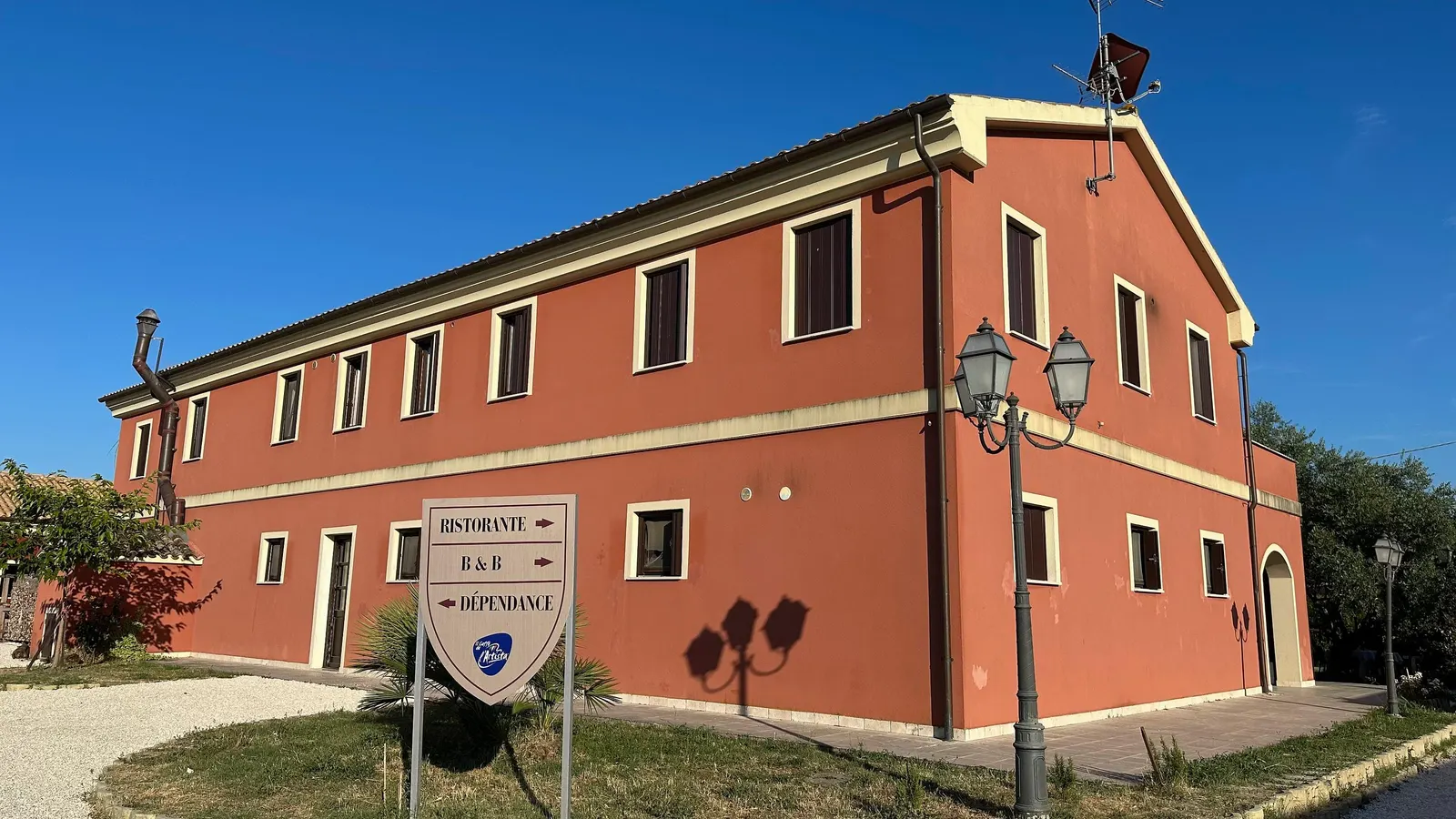 Il casale rosso con l'insegna: ristorante, B&B e dépendance